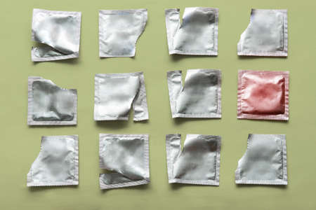 pattern of a condom and many empty packages on a green backgroundの写真素材