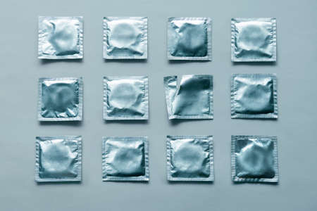 pattern of many blue condoms and empty package on blue background.の素材 [FY310163961803]