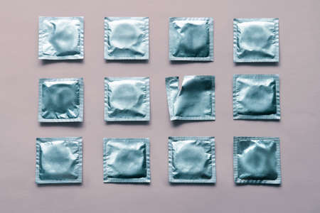 pattern of many blue condoms and empty package on pink backgroundの写真素材