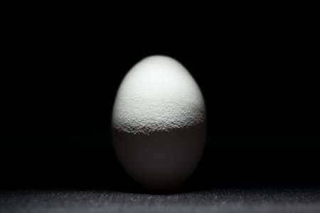 white egg on a black background in backlightの写真素材