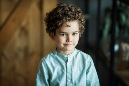 portrait of a curly boy on a dark background
