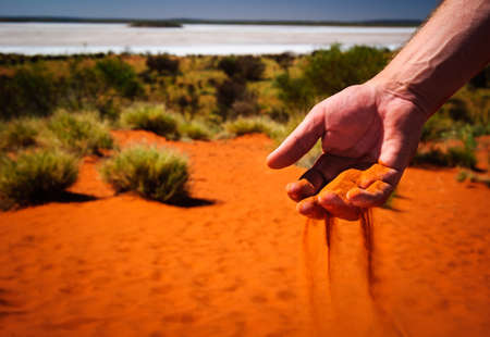 australia outback red sand through handの写真素材