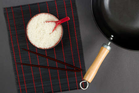 view on a table with wok and bowl with riceの写真素材
