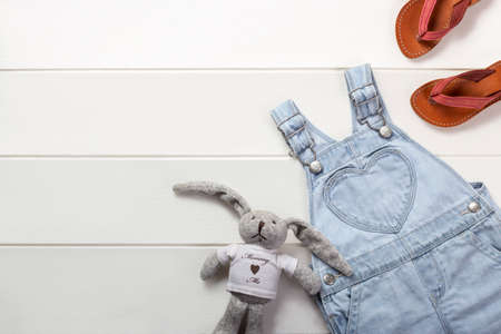 Top view of toddler girl bright jeans overall and leather flip flops on white backgroundの写真素材