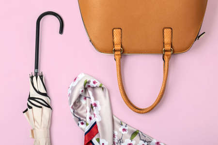Autumn theme flat lay of female leather handbag and other accessories on pastel pink backgroundの写真素材