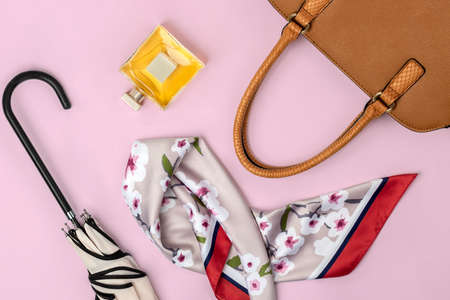 Autumn theme flat lay of female leather handbag and other accessories on pastel pink backgroundの写真素材