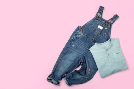 Toddler girl's shirt and overall flat lay on colorful pink backgroundの写真素材