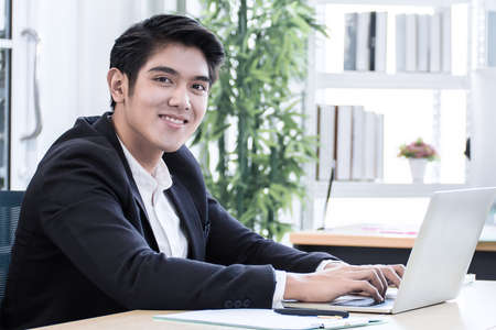 20s young business man is working and planning his project in the officeの写真素材