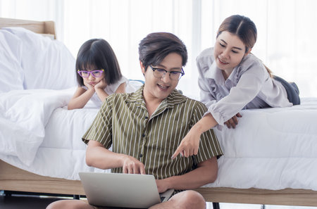 A warm family spending time and searching the internet together at home in holiday.の写真素材