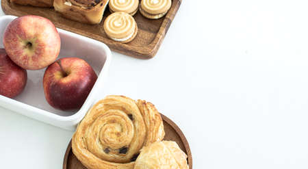 Top view of bakery and apples on white background with copy space