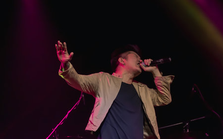 An asian male singer showing his porformance on stage. Entertainment and Concert Concept.の写真素材
