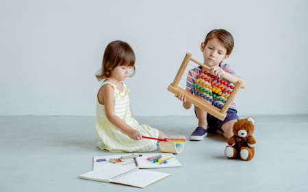 Caucasian little boy and girl playing toys together in a room at schoolの写真素材