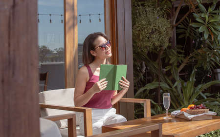 Asian beautiful woman wearing sunglasses, reading book and relaxing. Lifestyle and Travel Concept.の写真素材