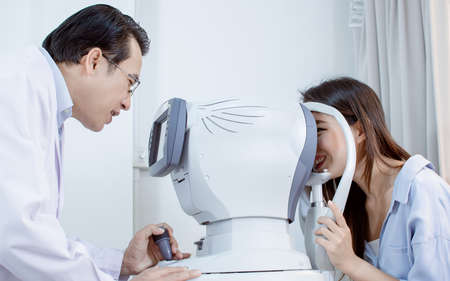 Ophthalmologist doing eyesight test to a woman in optical laboratory