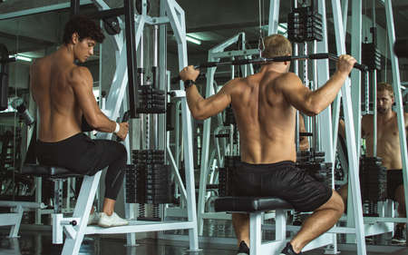 Portrait of Caucasian handsome muscular men doing exercise in gym. Sport Concept.の写真素材
