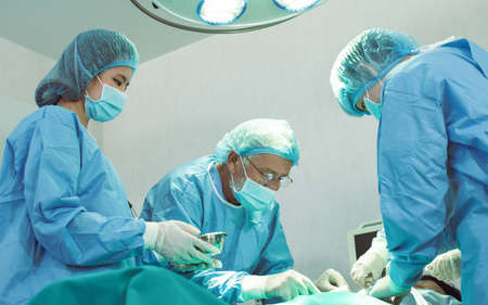Group of medical team urgently doing surgical operation and helping patient in theater at hospital