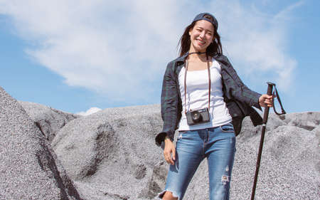 Asian beautiful woman wearing check shirt and cap, trekking and climbing mountains. Adventure Activity and Travel Concept.の写真素材