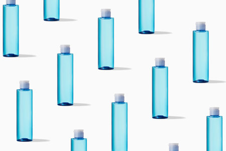 Pattern of blue transparent bottle with cosmetic product on white background. Mockup of skincare...