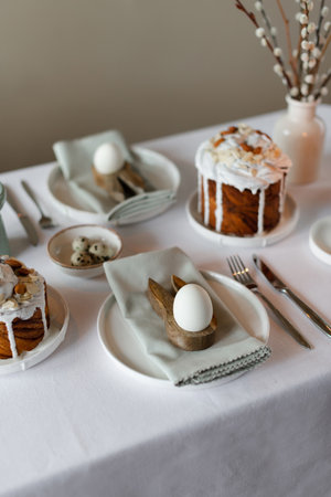 Happy Easter! Easter festive spring table setting decoration, eggs, Easter cake, willow branches in...