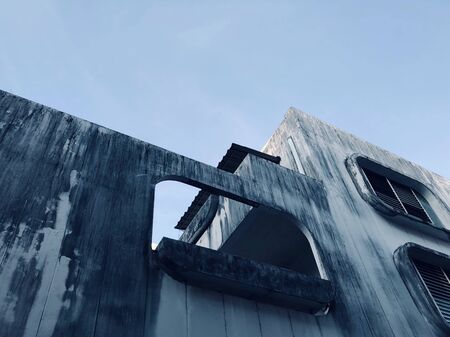 Abandoned buildings stretch up to the gray-blue sky in townの写真素材