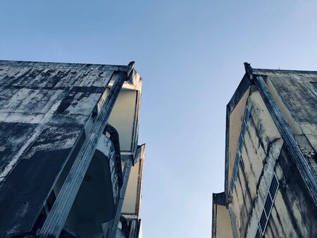 Abandoned buildings stretch up to the gray-blue sky in townの写真素材