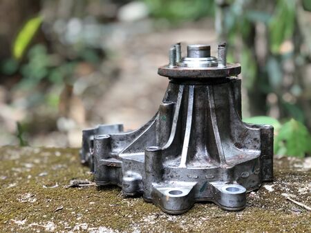 Auto parts, water pump removing from car engine in blur background