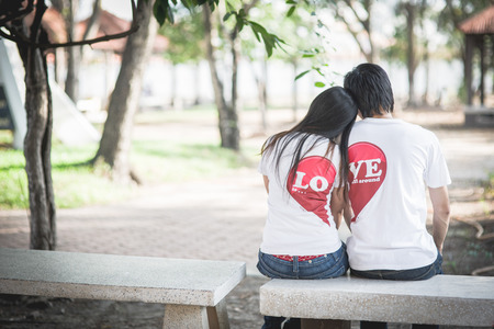 Loving couple sitting on a park bench together.の写真素材