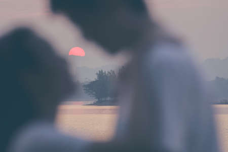 Blur loving couple silhouette kiss scene with sunset.の写真素材