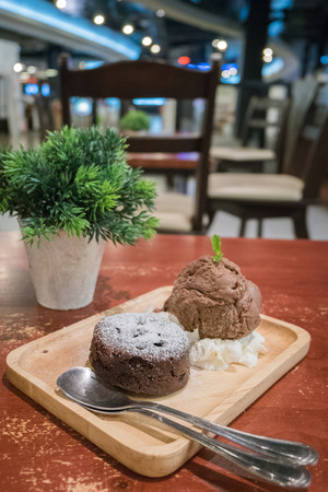 Chocolate lava cakes with chocolate ice cream scoop on wooden dishの写真素材