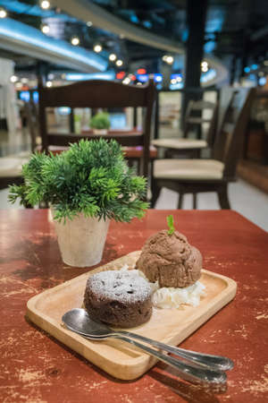Chocolate lava cakes with chocolate ice cream scoop on wooden dishの写真素材