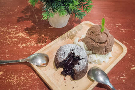 Chocolate lava cakes with chocolate ice cream scoop on wooden dishの写真素材