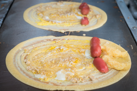 Khanom Tokyo is a thin flat pancake filled with sweet custard cream. Some have a savory filling, like pork or sausage. It is a Thai street snackの写真素材