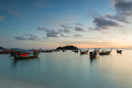 Long exposure silhouette long tail boats with sunrise sky in Koh Lipe Island.Soft focus and motion blur due to long exposure shotの写真素材