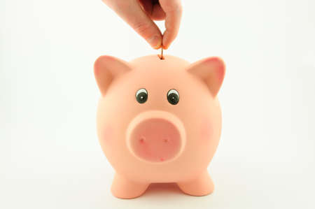 Put a coin into a piggy bank   To make contribution to the financial marketの写真素材