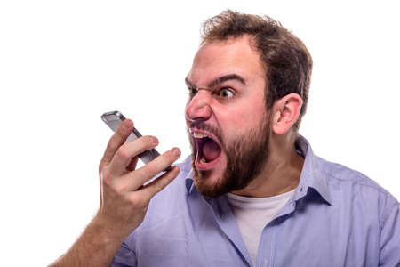 Bearded man shouting angrily into his mobile phone