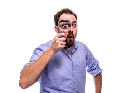 Funny business man looking surprised with magnifying glassの写真素材