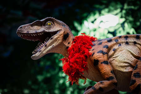 Dinosaur model with red feather boa, close-up.の写真素材