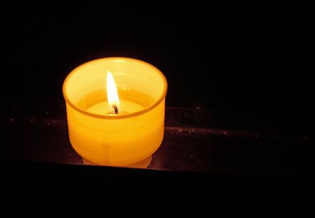 Burning prayer candle in the darknessの写真素材