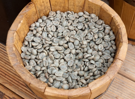 Green coffee beans in wooden bowlの写真素材