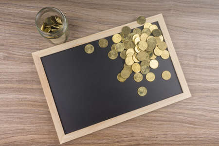 Gold coins in glass jar on chalkboard. Financial concept.