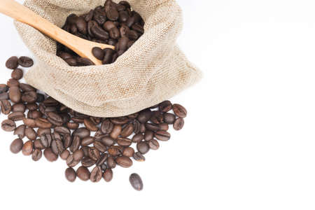 Coffee beans inside burlap bag on white background. Selective focus.の写真素材