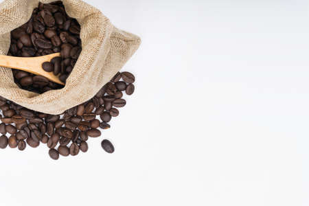 Coffee beans in and outside burlap bag on white background. Selective Focus. Top View.の写真素材