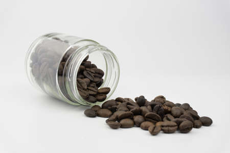 Spilled coffee beans from glass jar