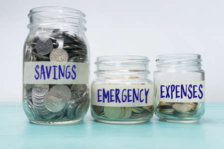 Coins in glass jar contains coins for expenses, emergency and savings. financial concept.