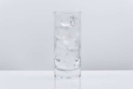 Glass with ice cubes on whie background.の写真素材