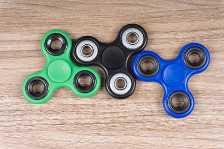 Group of fidget spinner stress relieving toy on wooden background.の写真素材
