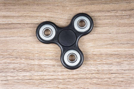 Fidget spinner stress relieving toy on wooden background.の写真素材