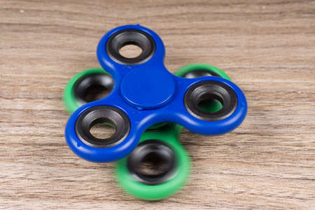 Group of fidget spinner stress relieving toy on wooden background.の写真素材