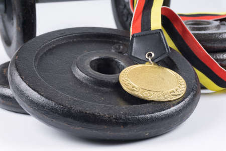 Fitness equipment : Training dumbbells and gold medal isolated on white background.