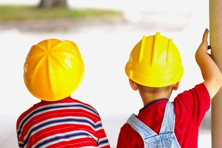 Two boys wearing hard hats viewed from behindの写真素材